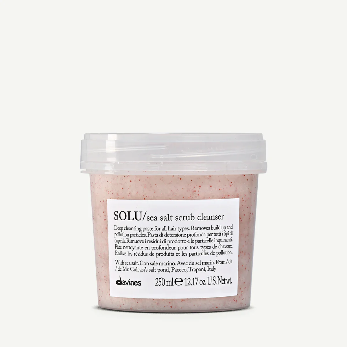 Container of SOLU/sea salt scrub cleanser with a white label, clear lid, and pink scrub texture visible
