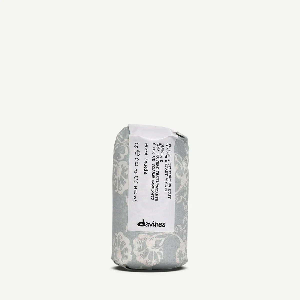 A portable, wrapped textile product with a floral design and a label from Davines, describing it as an instant volumizing dust for hair.