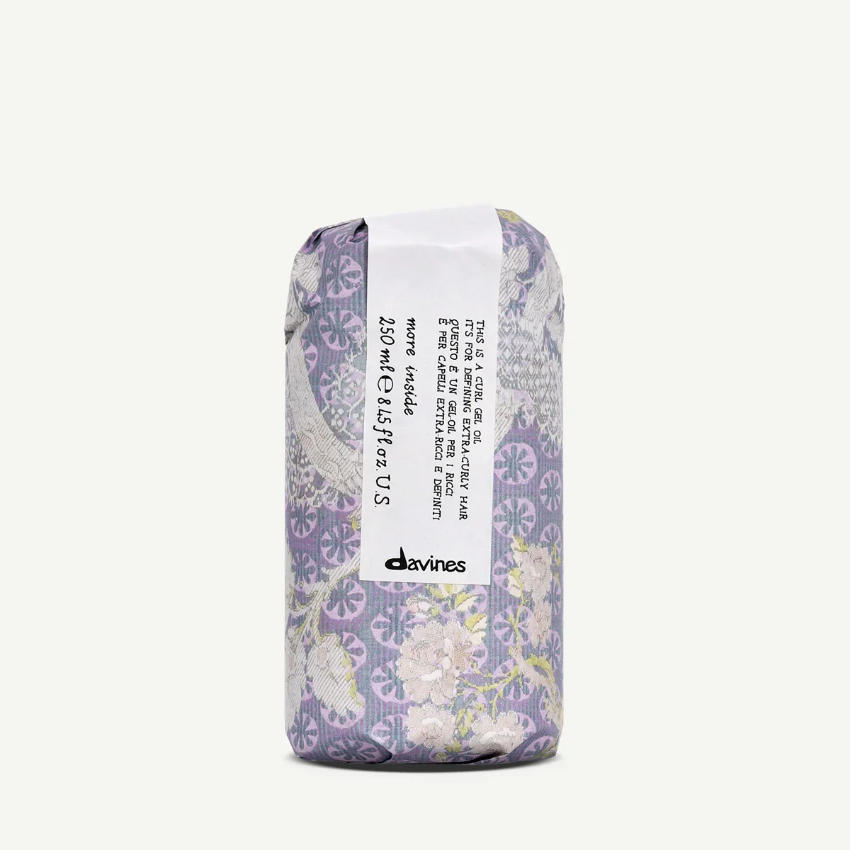 Wrapped bar of Davines curly gel oil with purple floral and leaf pattern packaging, featuring a white label with product description and branding.