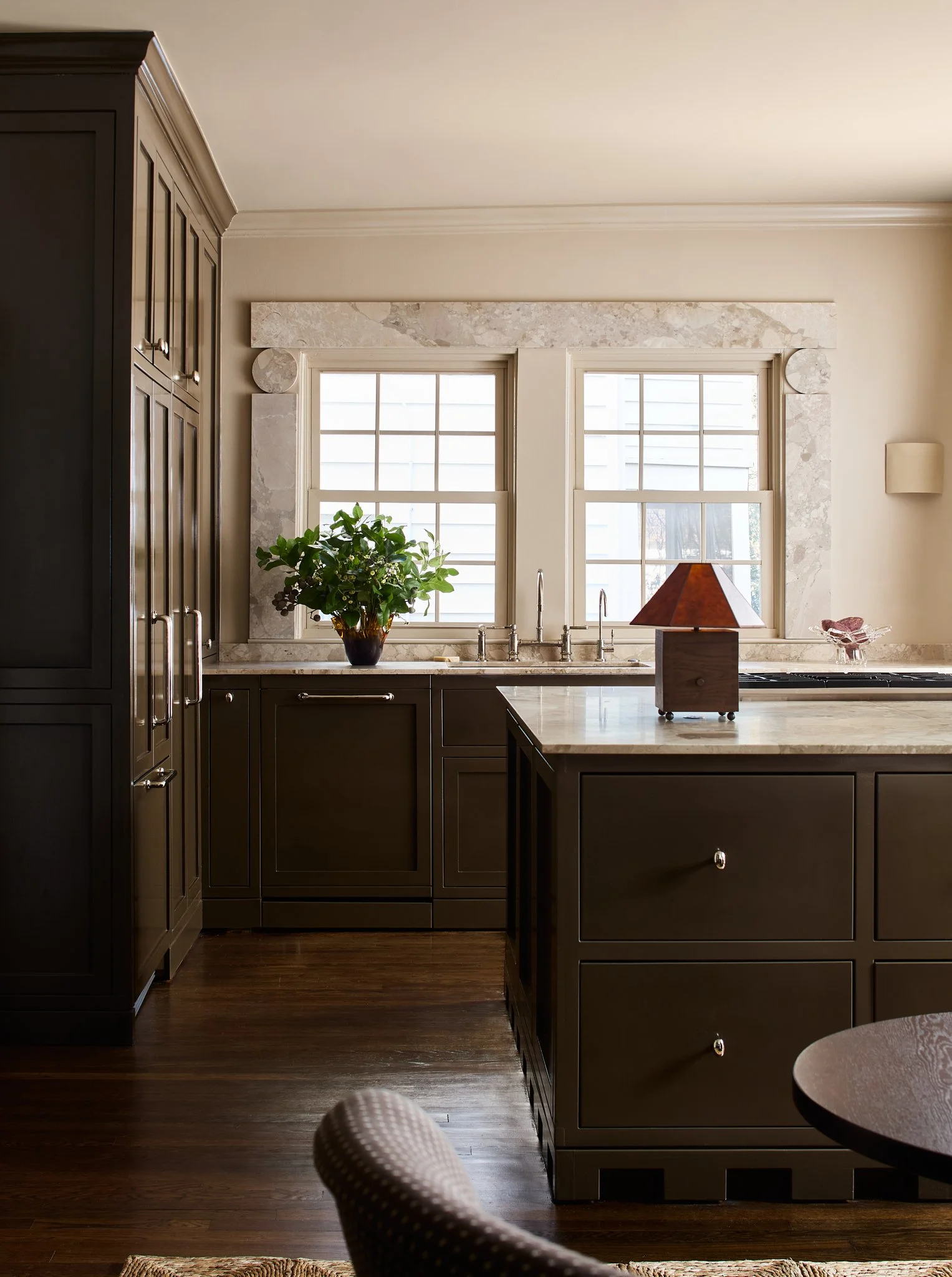 The Carley table lamp on a kitchen island with dark cabinetry and sunlit windows in the background.