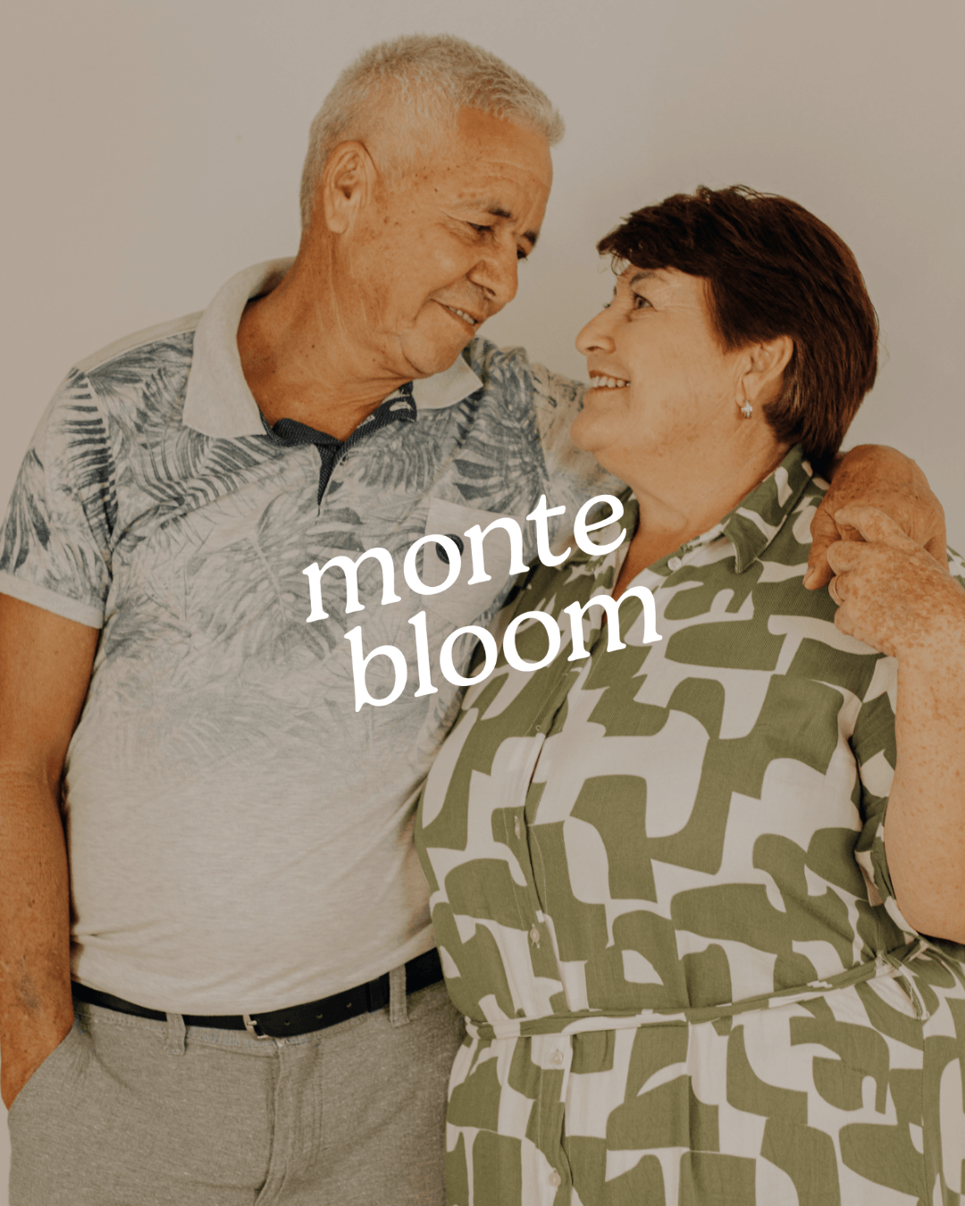 An elderly man and woman share a loving moment, smiling at each other and embracing, with the text 'monte bloom' overlaid on the image.