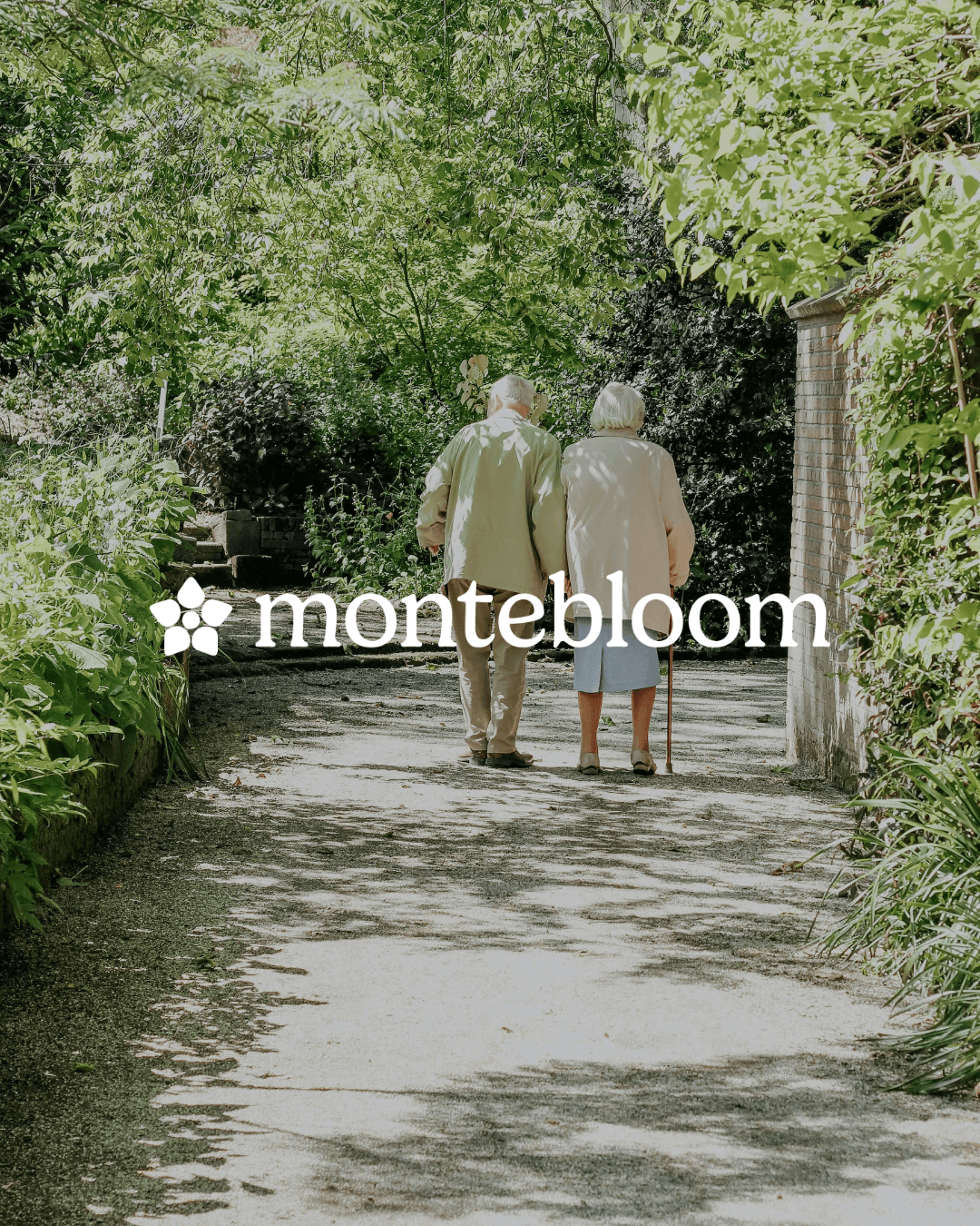 Older man and woman walking together on a shaded garden path