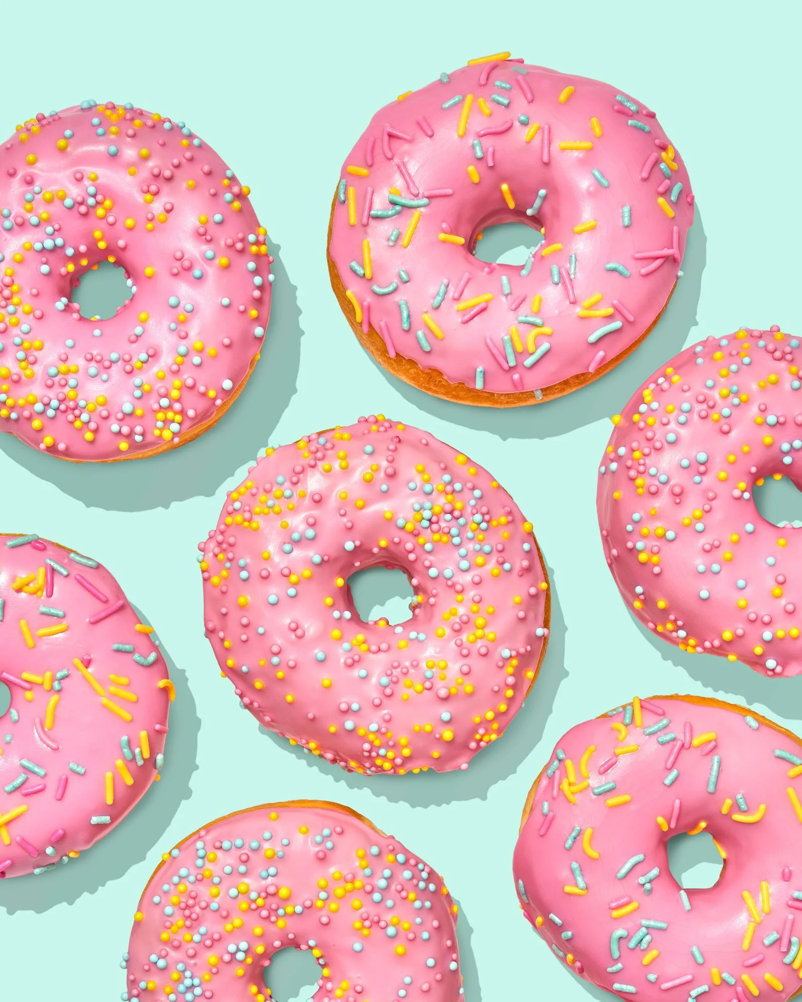Pink iced donuts on a light aqua background