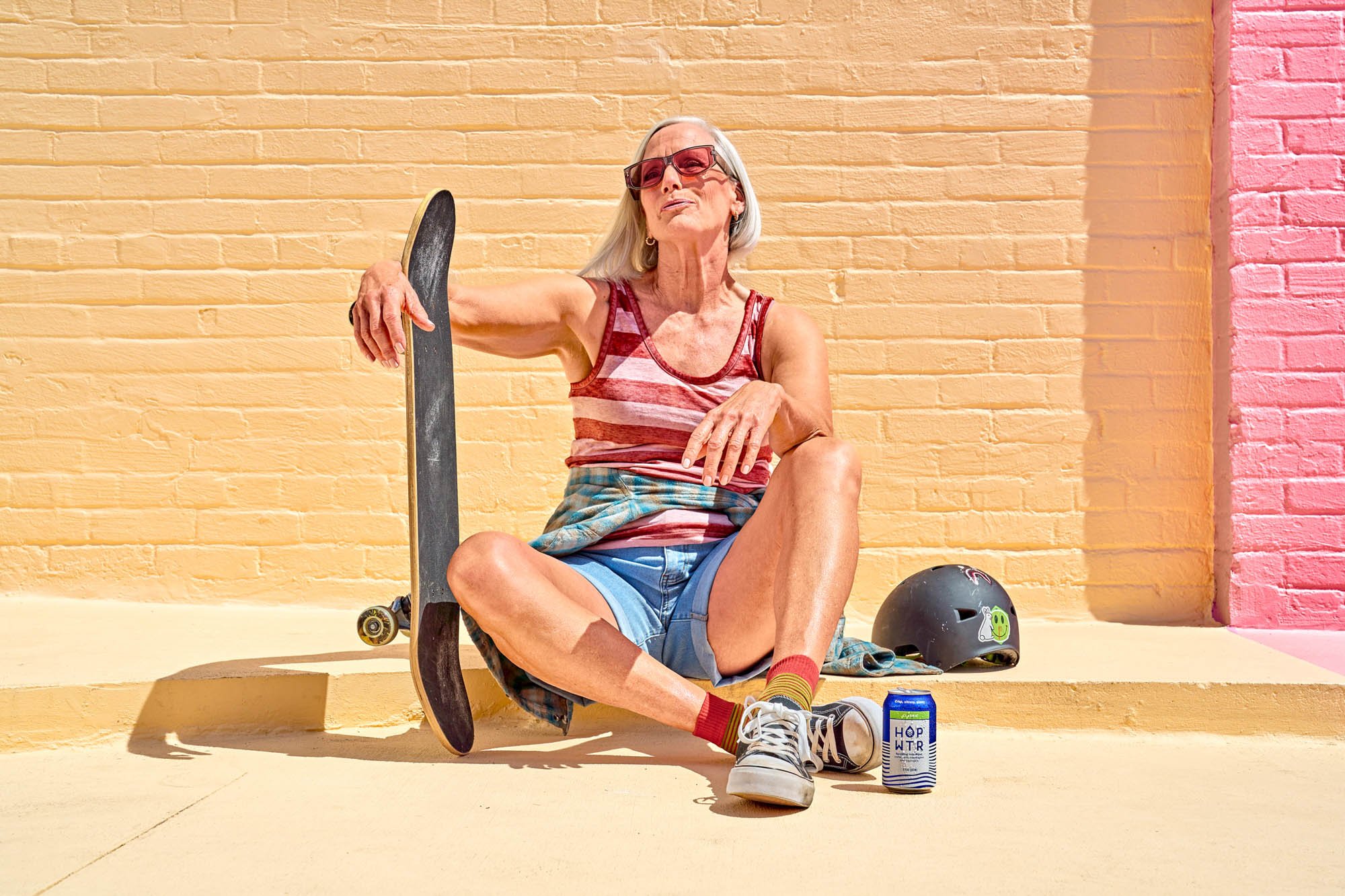Skateboarder rests after a ride and enjoys a beverage to cool off. A commercial lifestyle branding campaign