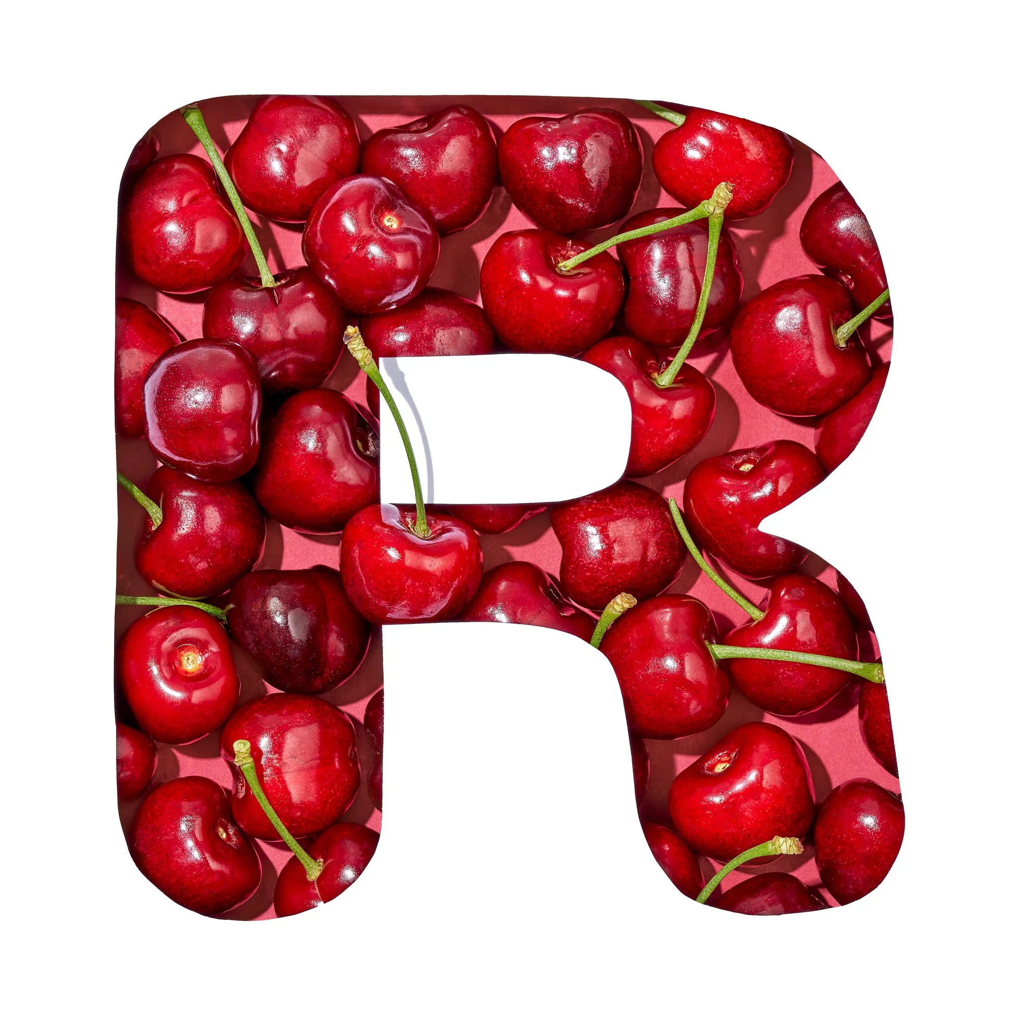 The letter R filled with dark red cherries on a coral pink backdrop, part of Suzanne Clements' produce-spelled SUMMER title card for the Publix summer campaign.