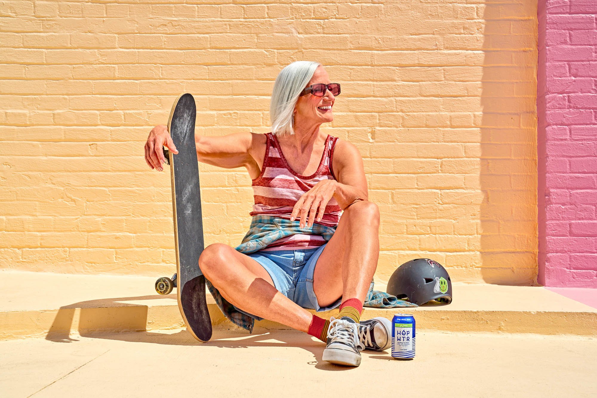 Laid back and very very cool, this female skateboarder takes a break to rest and refresh