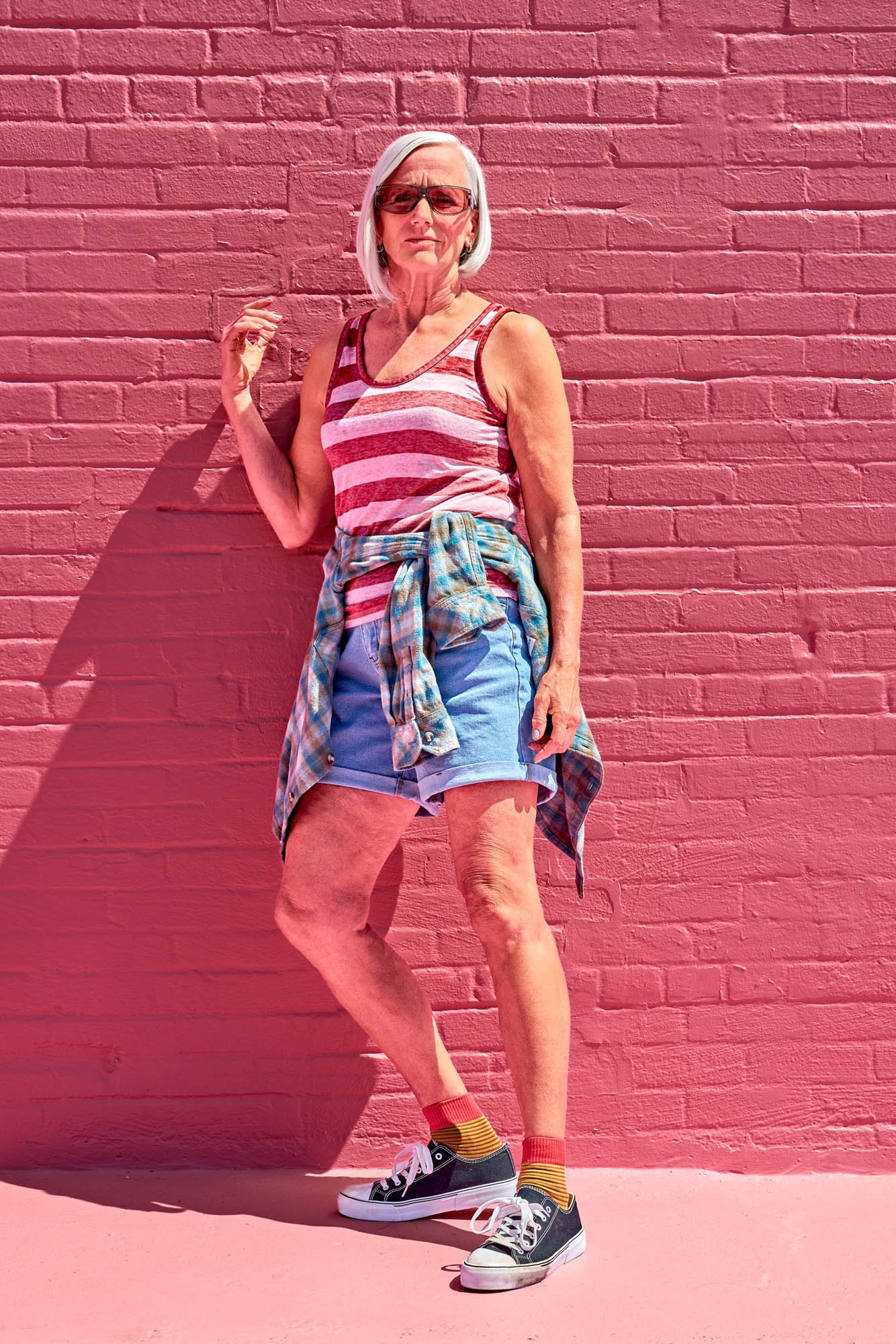 Mature woman portrait against a vibrant pint wall shot on location in orlando florida for a commercial lifestyle campaign