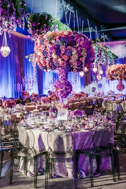 Tall purple wedding flowers centerpiece with pink accents at a reception