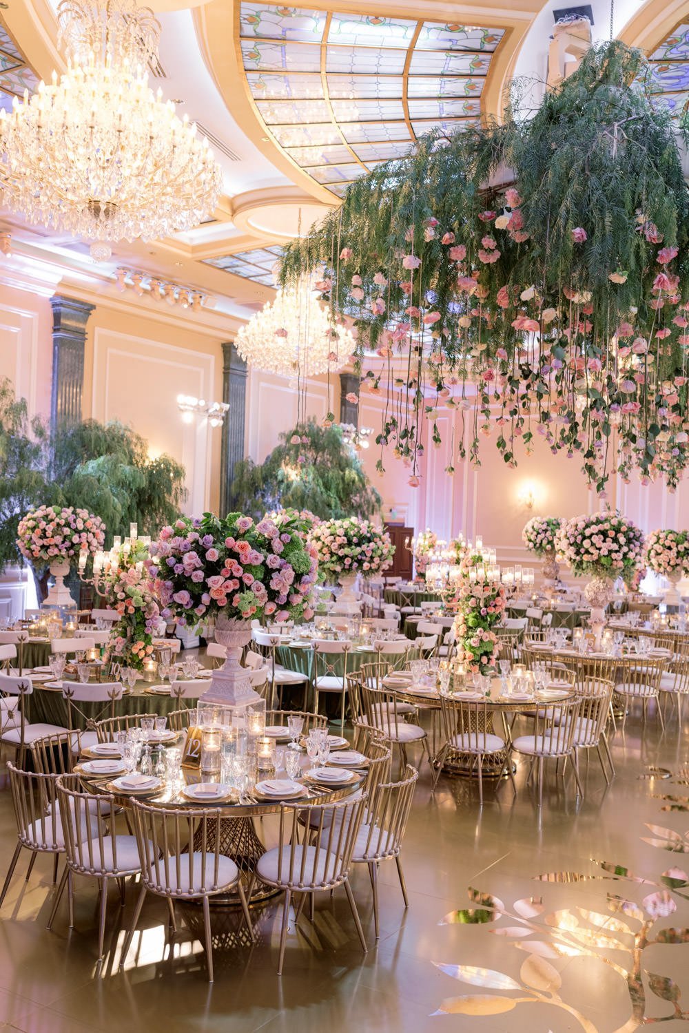 Cascading deep pink and cream roses surround gold and cream table settings to create an enchanted garden the beautiful Taglyan Cultural Complex