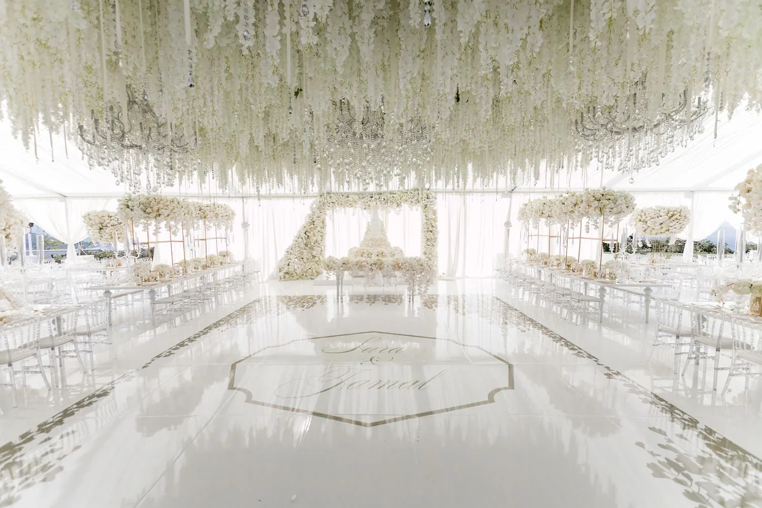 Dance floor with custom monogram beneath a wisteria ceiling at a tented wedding