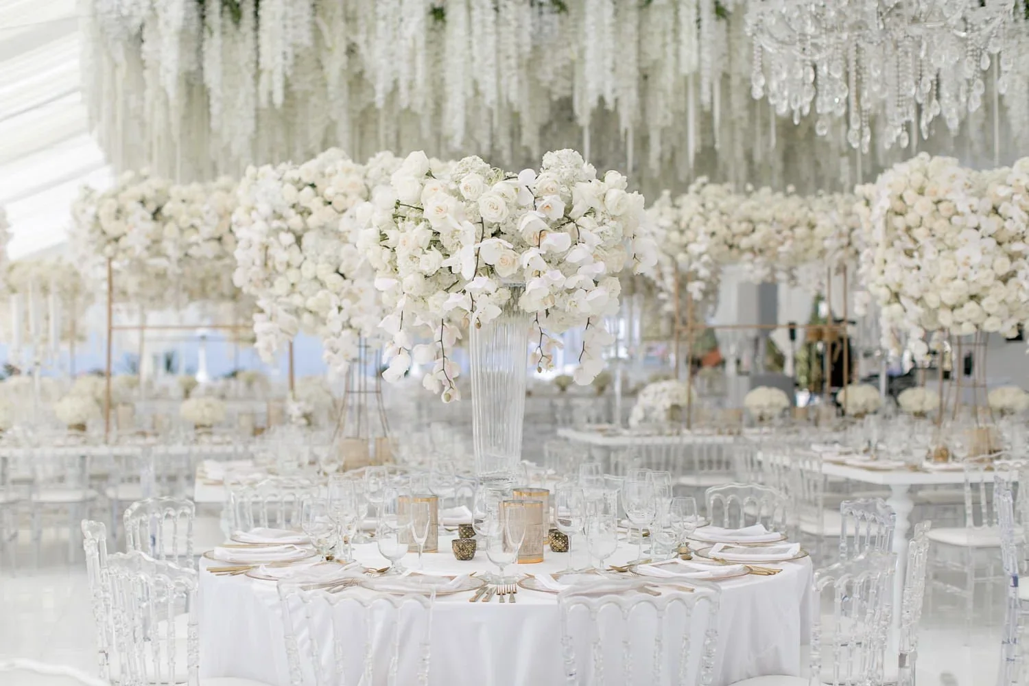Long reception table with gold-framed floral installations and crystal candelabras