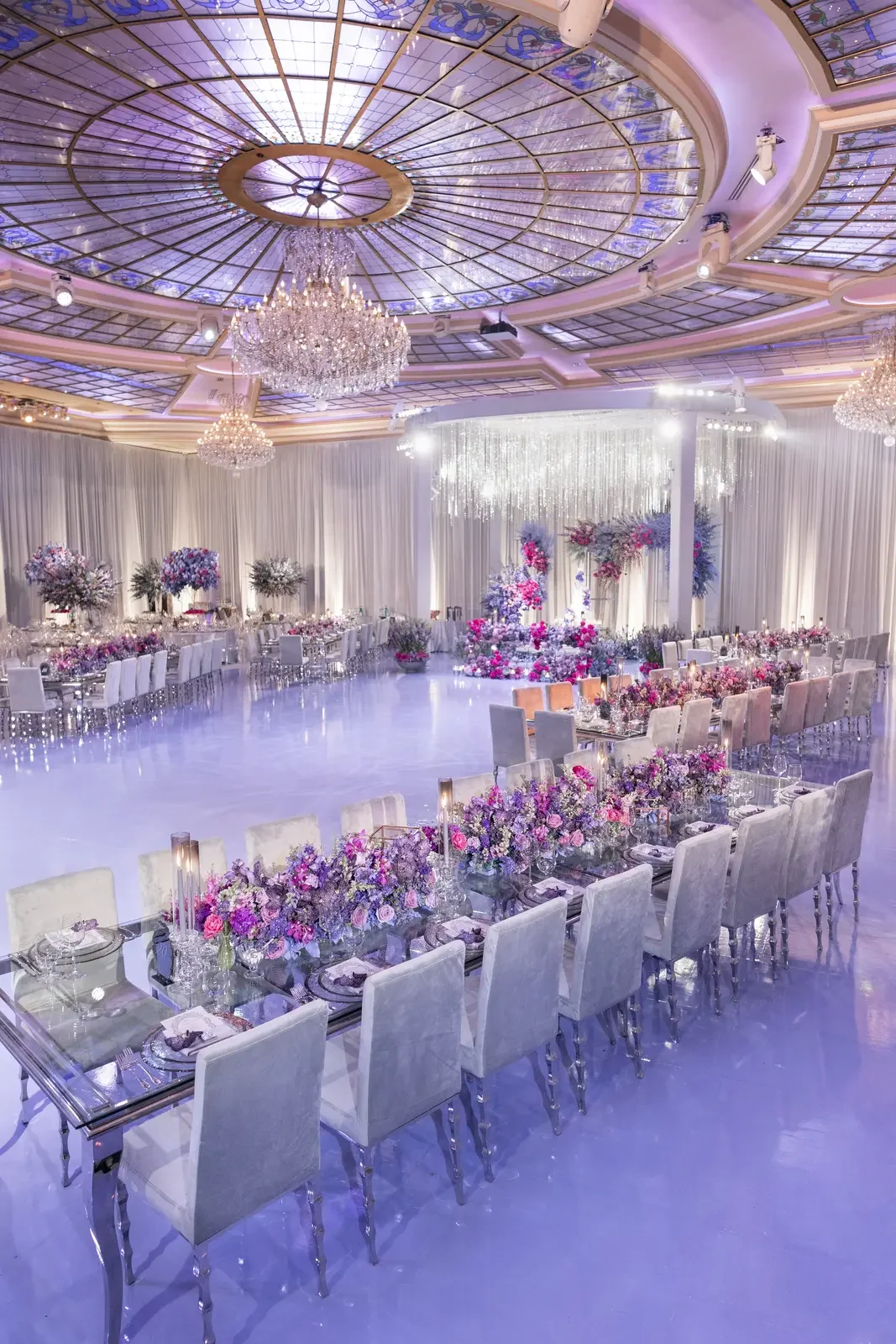 Purple wedding theme reception beneath a stained glass dome ceiling