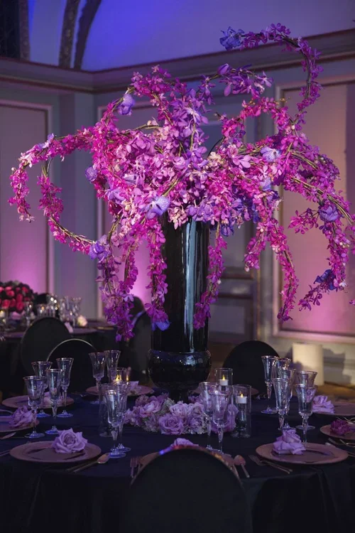Purple wedding colors orchid arrangement in a black vase centerpiece