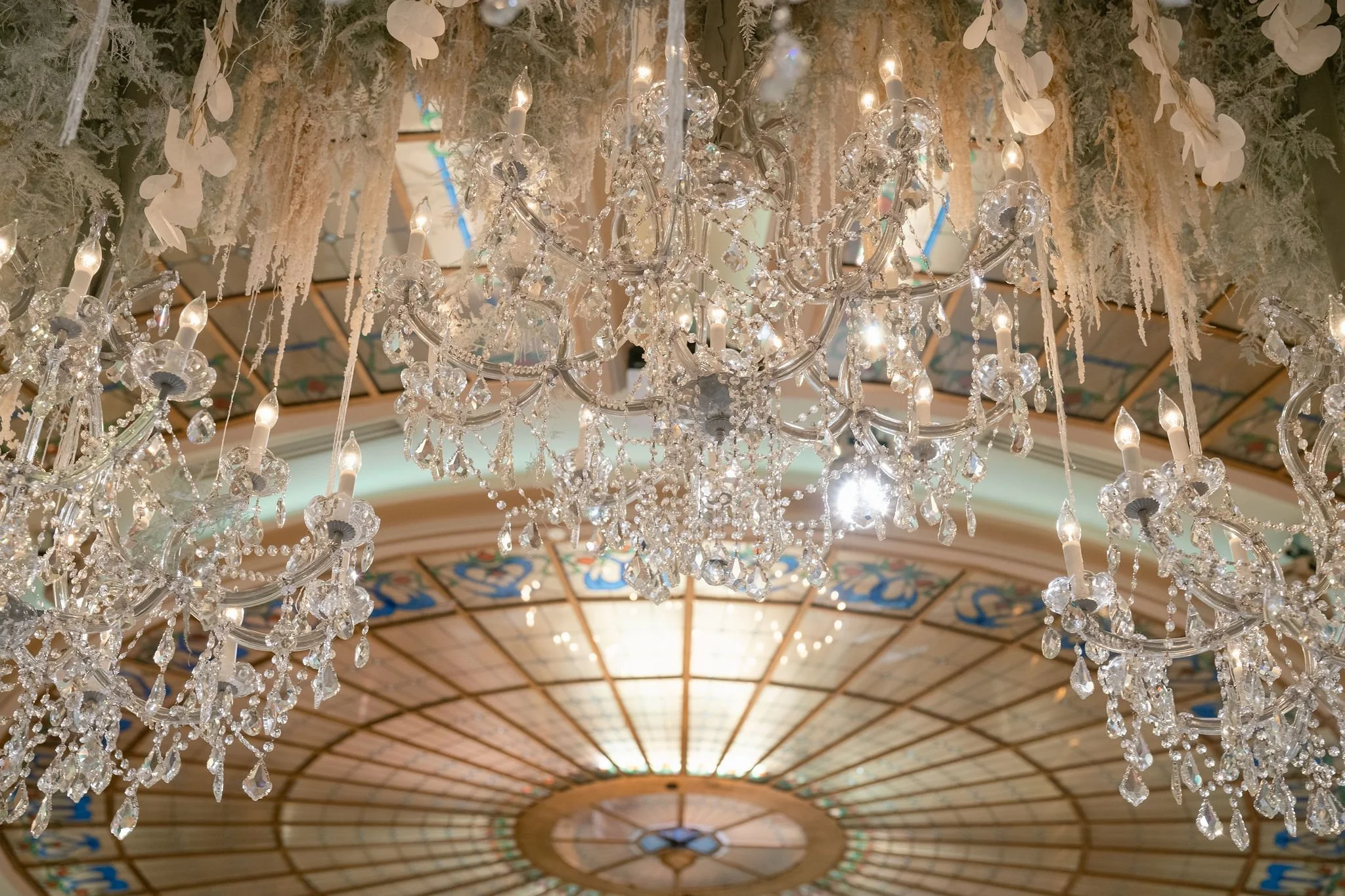 Wedding Reception Featuring a Statement Ceiling Design with Suspended Florals and Ambient Glow