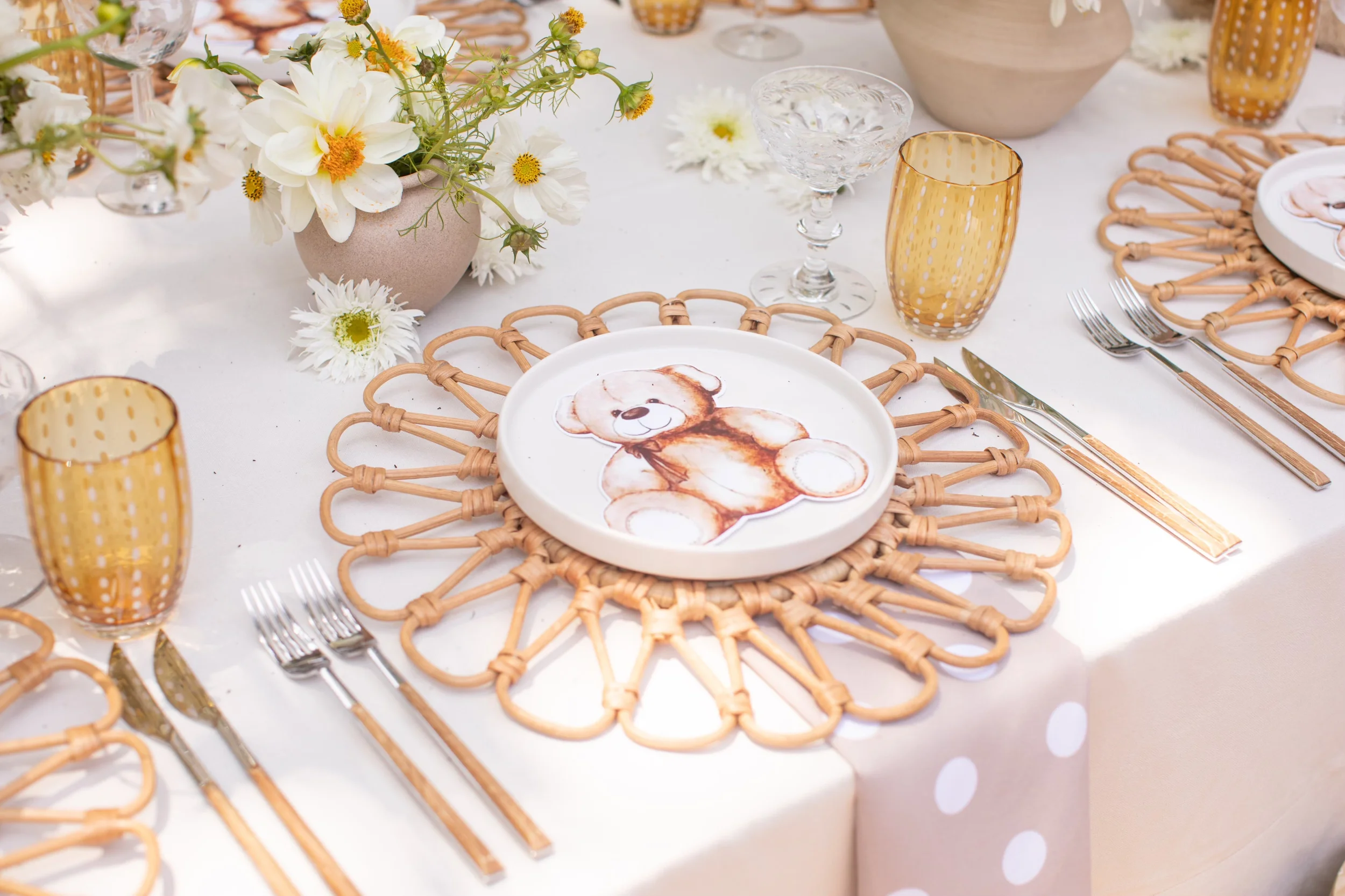 Teddy bear baby shower tabletop details with amber glassware, florals and woven chargers