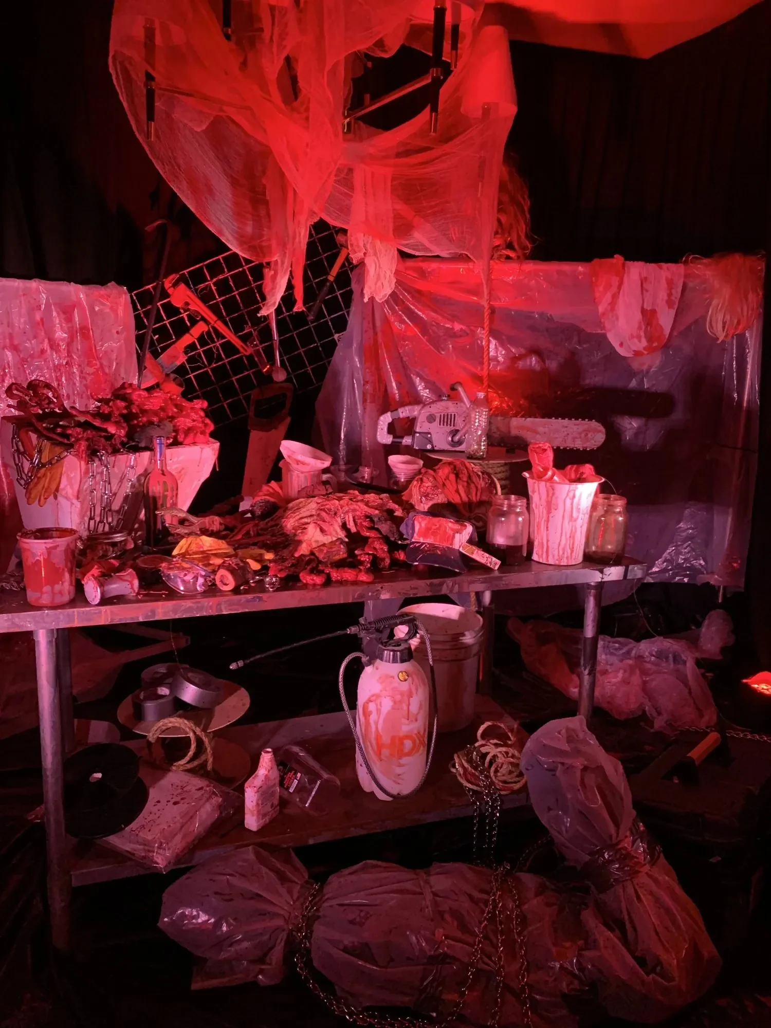 Horror-themed Halloween set design with a butcher table and props, created by Eddie Zaratsian's Halloween decorators in Los Angeles