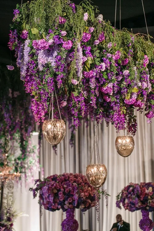 Hanging lavender wedding colors floral installation with gold votive candles