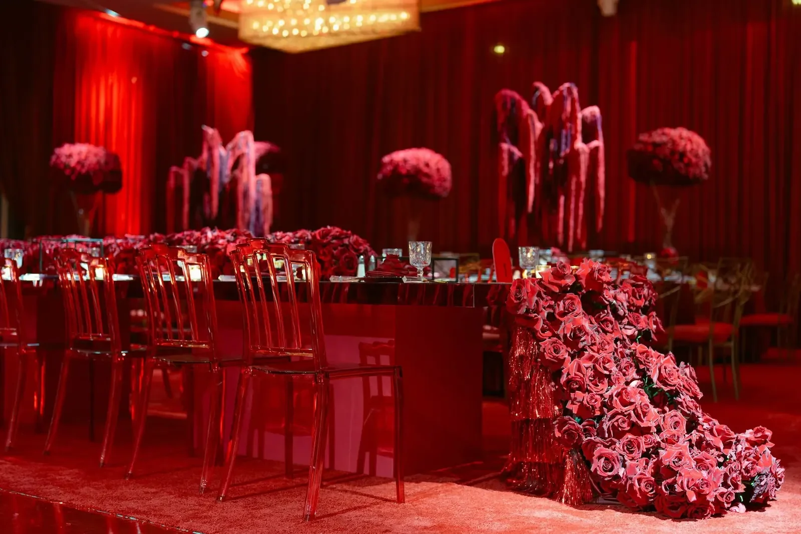 Cherry red sweet 16 birthday design by a party planner, with rose centerpieces and a fully red-lit room
