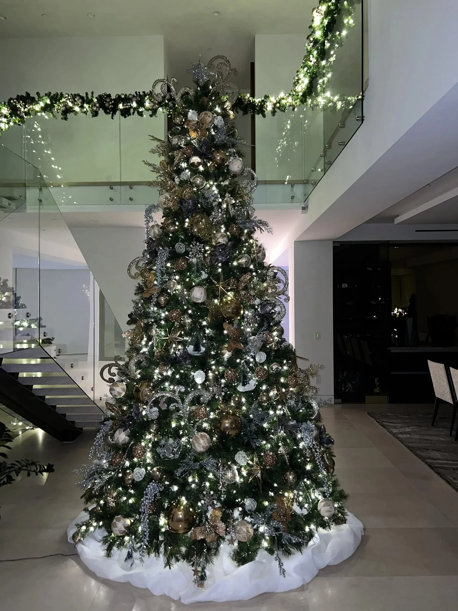 Gold and silver Christmas tree and staircase garland in a modern Los Angeles home, by Eddie Zaratsian's residential Christmas decorating service