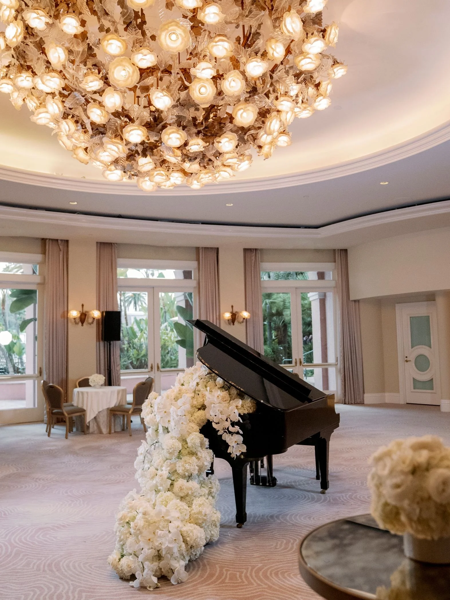 Wedding Planner Designing a Piano Floral Installation with Candles and Custom White Furnishings at the Beverly Hills Hotel