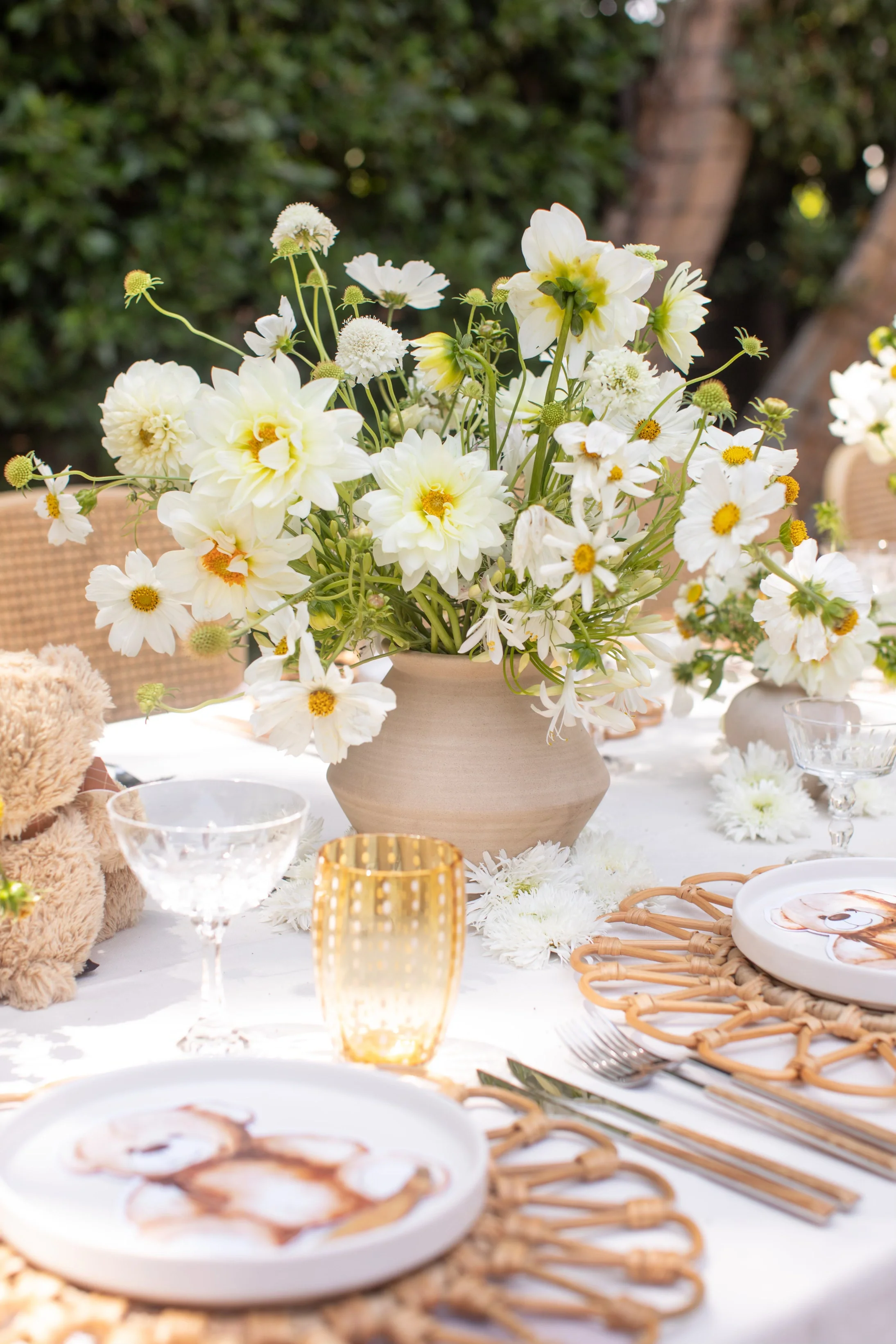 Garden-style floral centerpiece featuring white seasonal flowers for a teddy bear baby shower