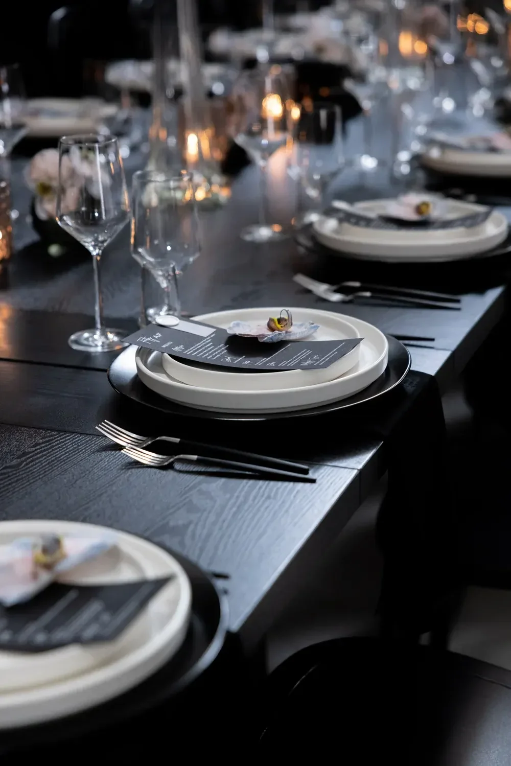 Black and white place setting with a custom menu card and fresh orchid, designed by a party planner