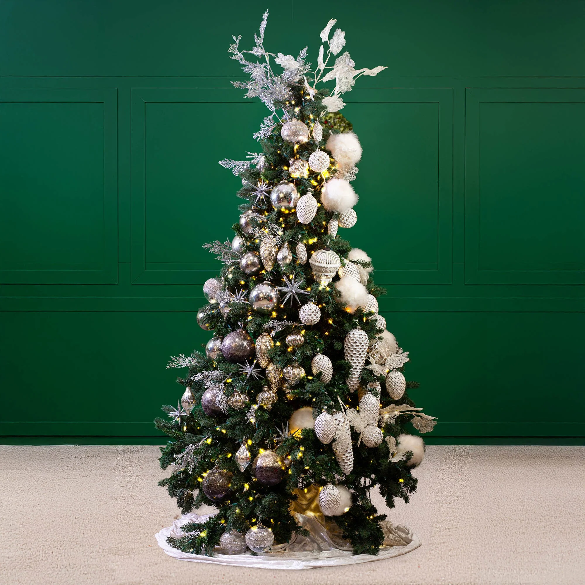 Green and silver Christmas tree with layered ornament styling