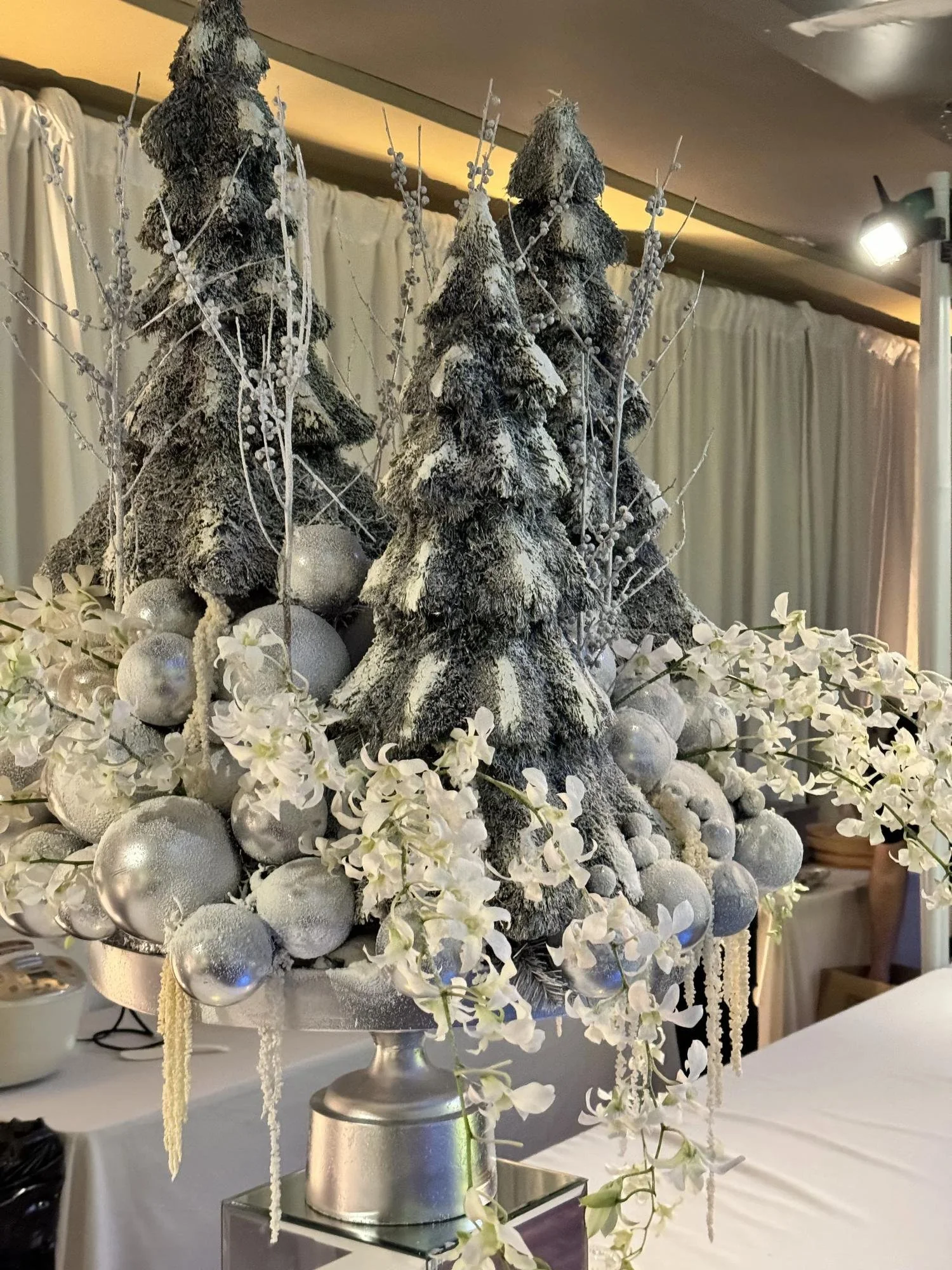 Winter white Christmas flower arrangement with frosted trees, silver ornaments and orchids, by Eddie Zaratsian in Los Angeles