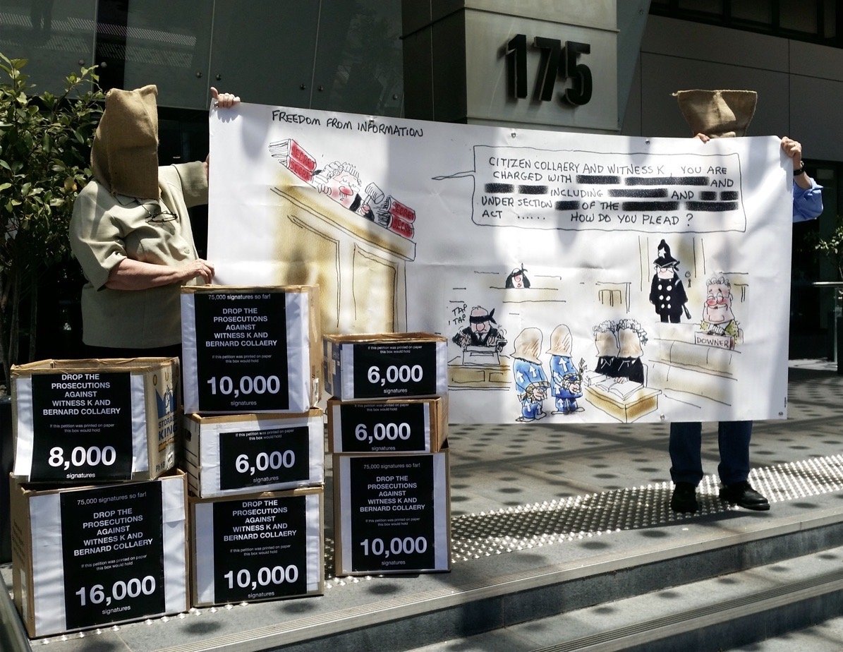 Susan Connelly with petition signatures and Moir cartoon banner outside CDPP office Sydney, 13 Dec 2021