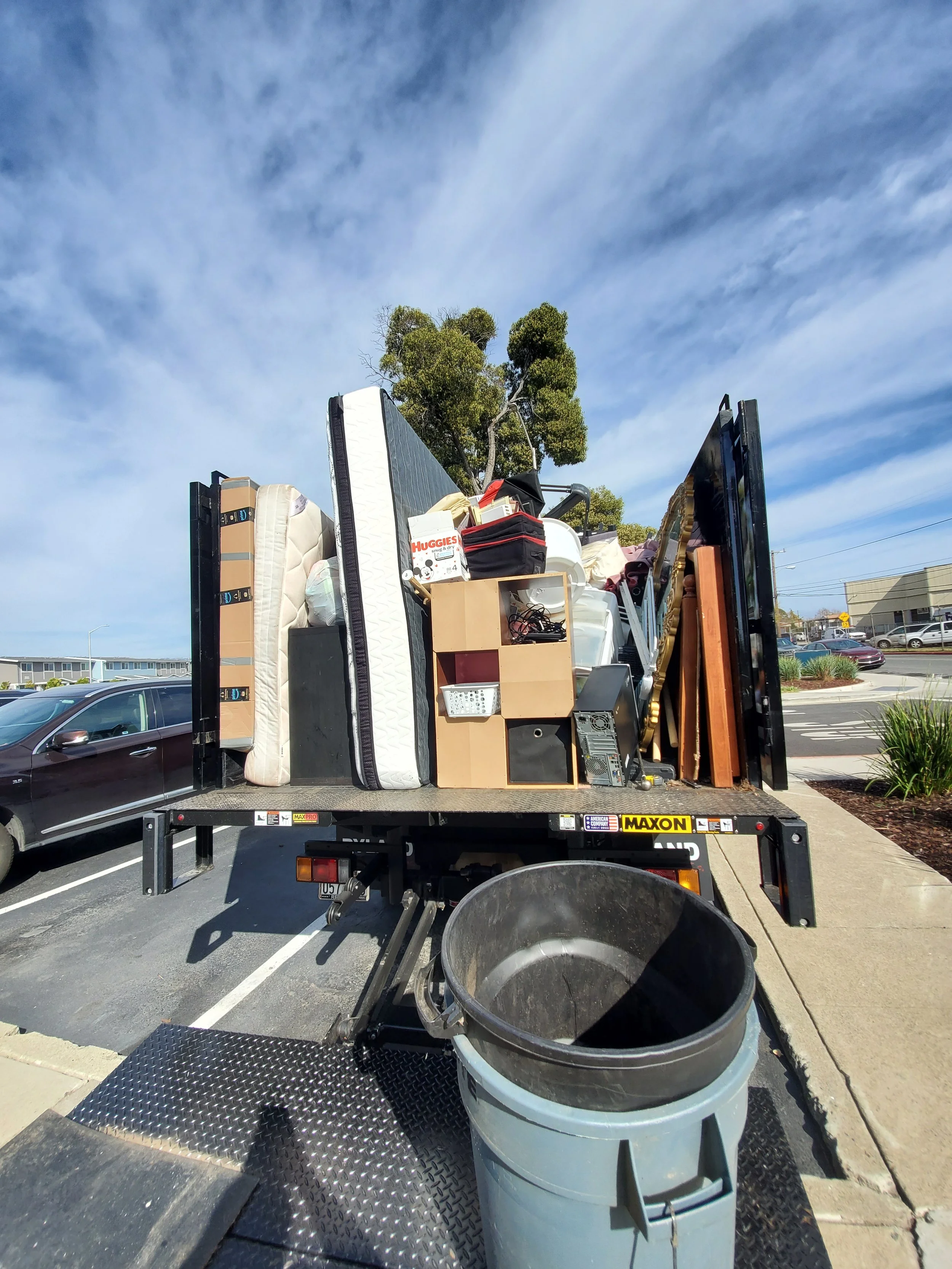 Junk removal truck loaded with mattresses, furniture, and household items in the Bay Area