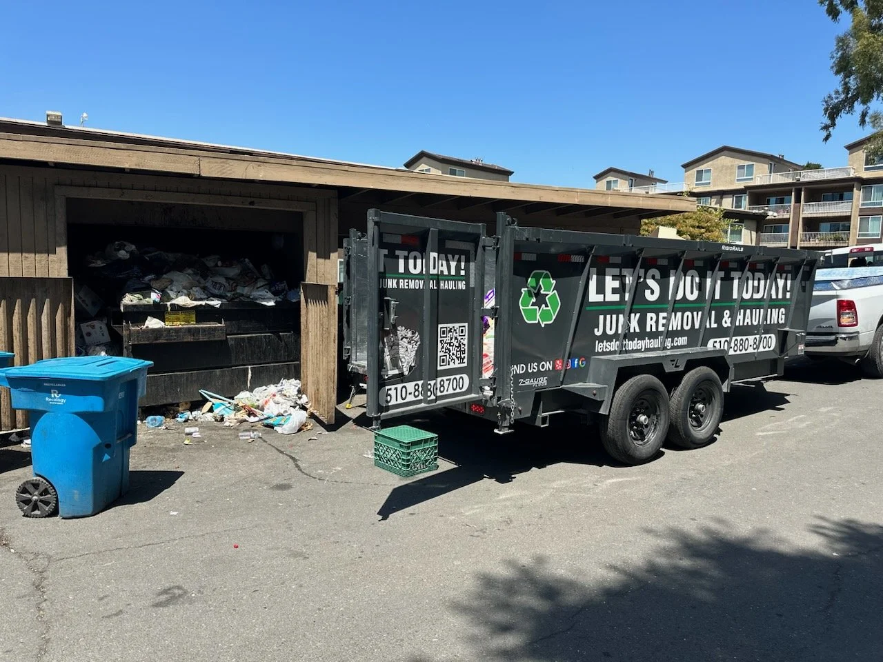 Let's Do It Today trailer loaded with junk from a property trash enclosure cleanout