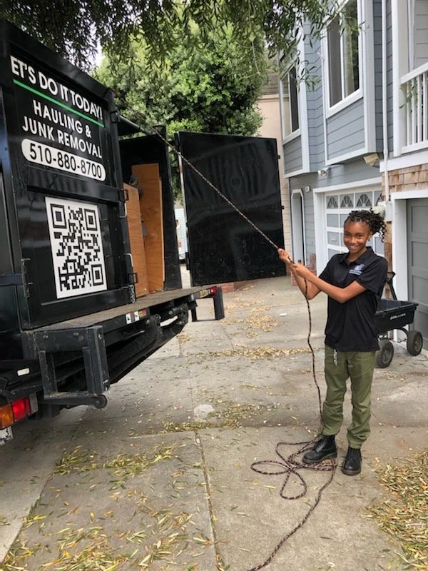 Let's Do It Today crew member securing a load on the junk removal truck