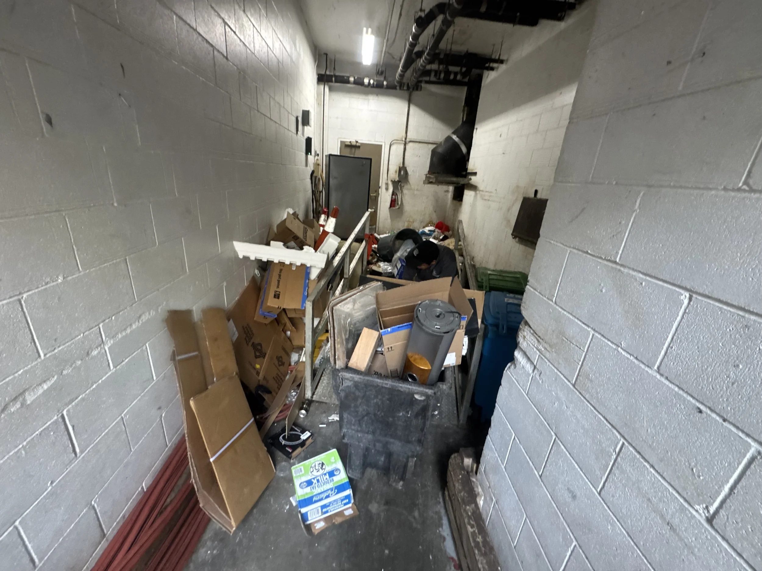 Cluttered basement trash area at a luxury apartment community before junk removal