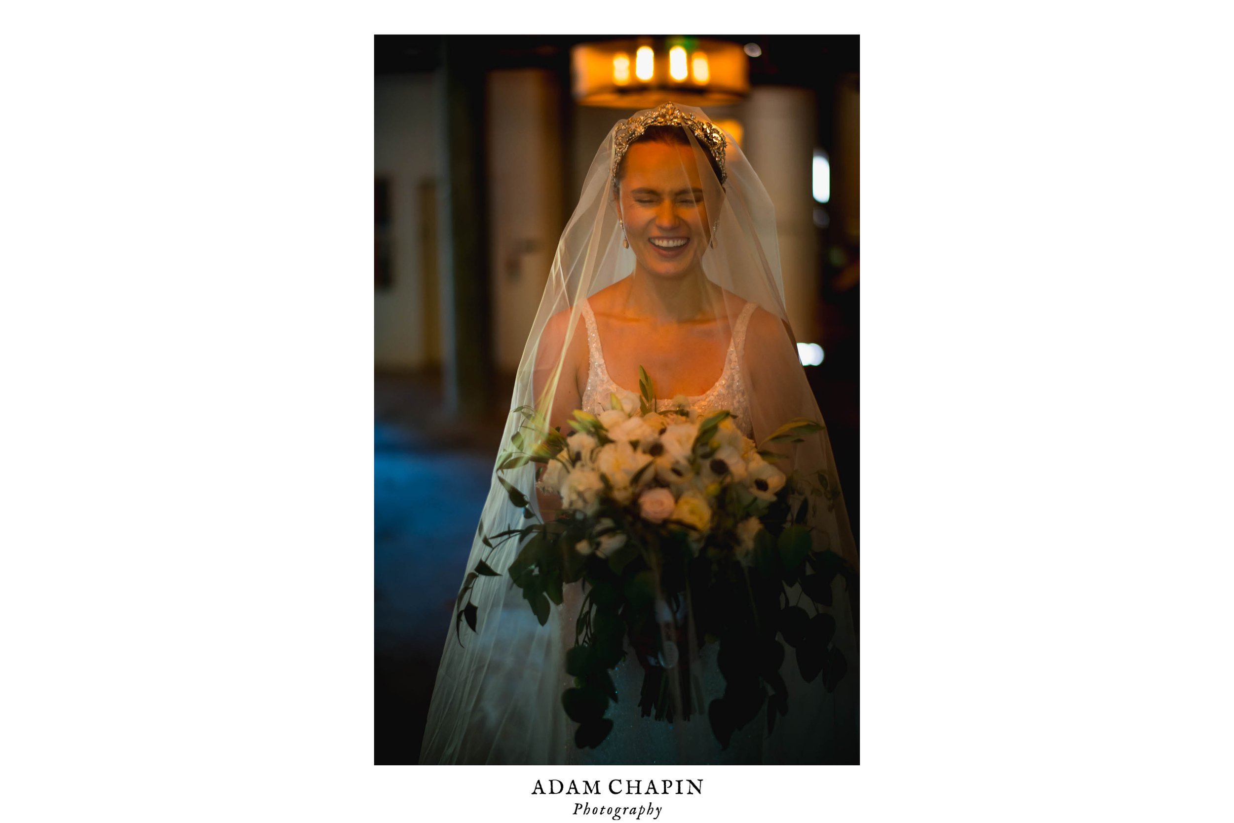 bride laughing while covered in her veil