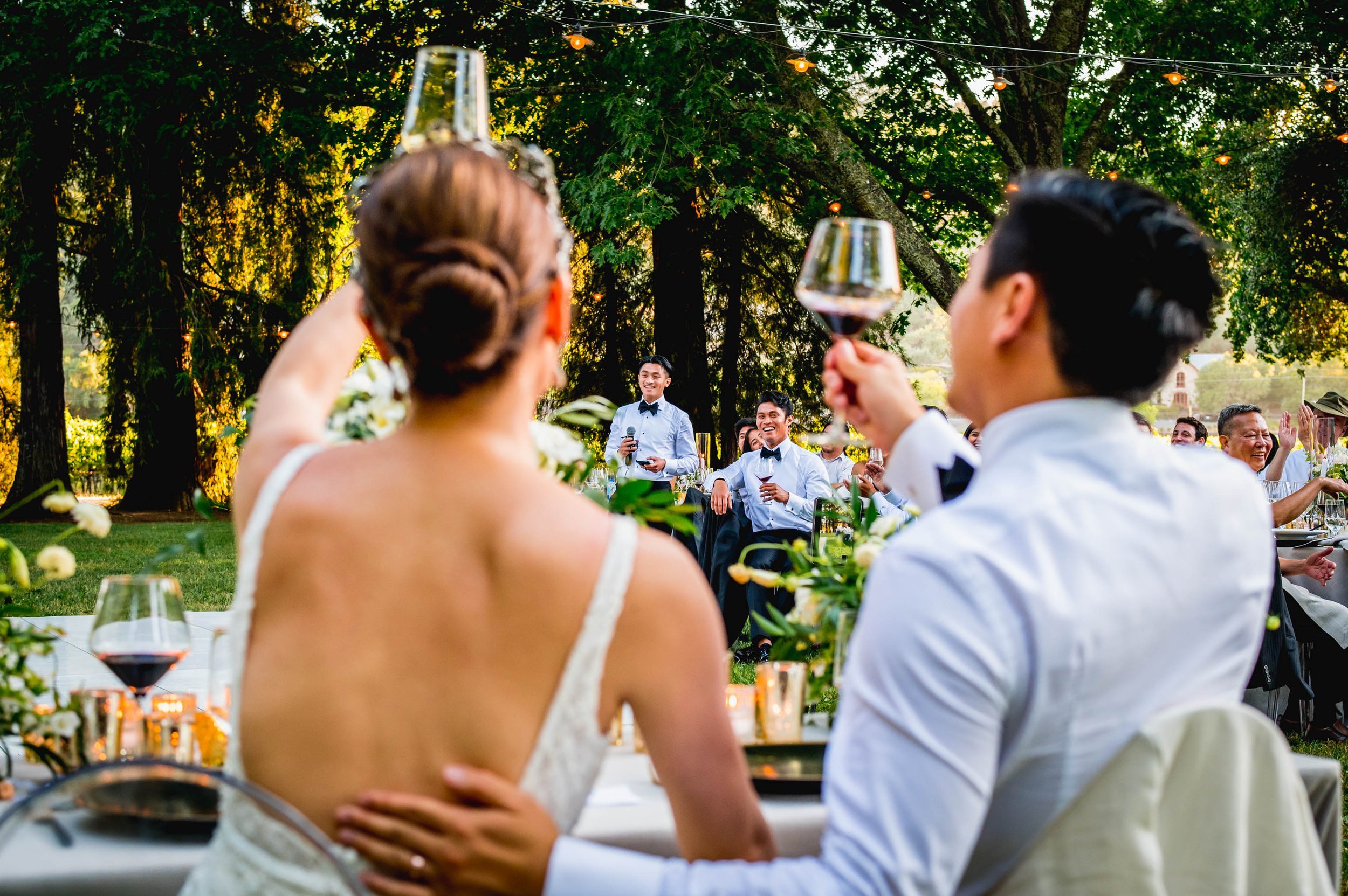 the bride and groom cheers their wine glasses to the grooms brothers following a toast