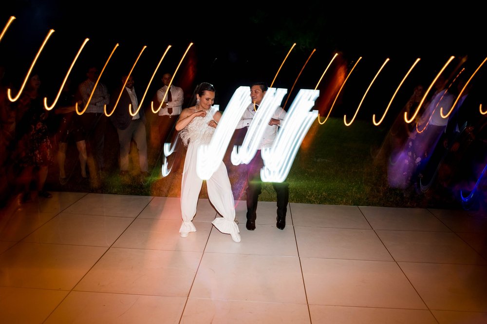 light blurs behind the bride and groom as they begin a choreographed dance at their wedding reception