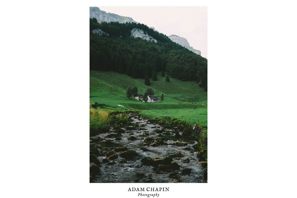 swiss farm house and a stream at the beginning of the ebenalp trail in weissbad switzerland by adam chapin photography