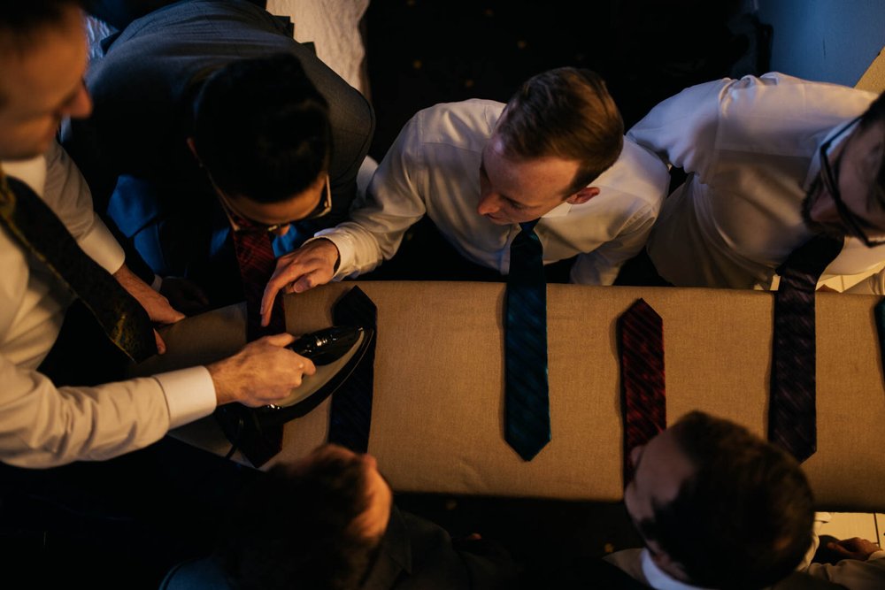 groom irons his groomsmens ties