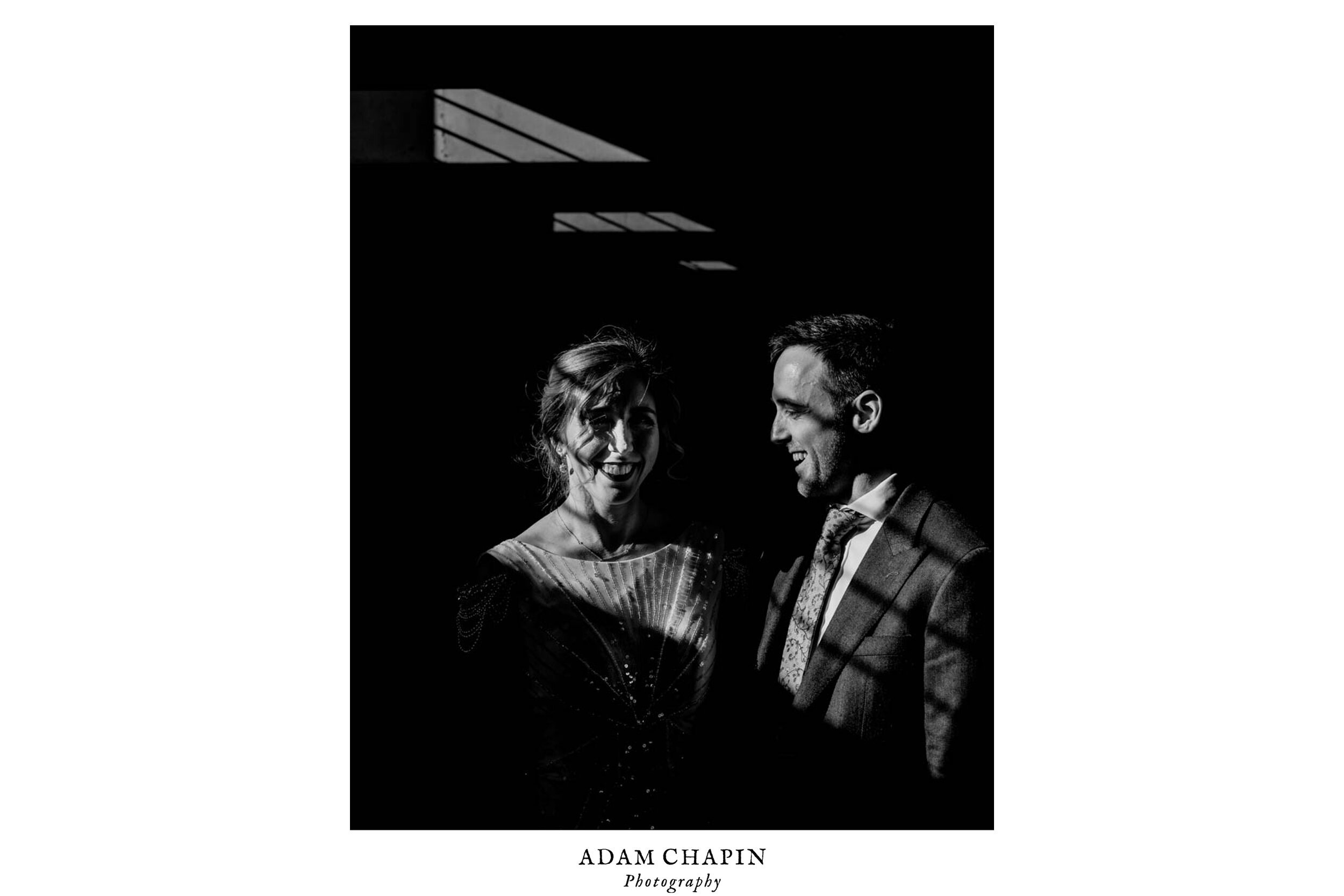 bride and groom pose in the parking garage after their first look