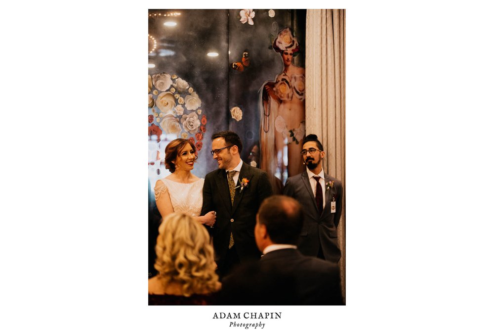 groom looks at bride during speech in ceremony