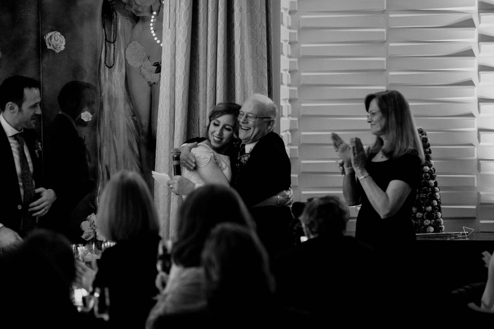 bride hugging father of the groom during toasts