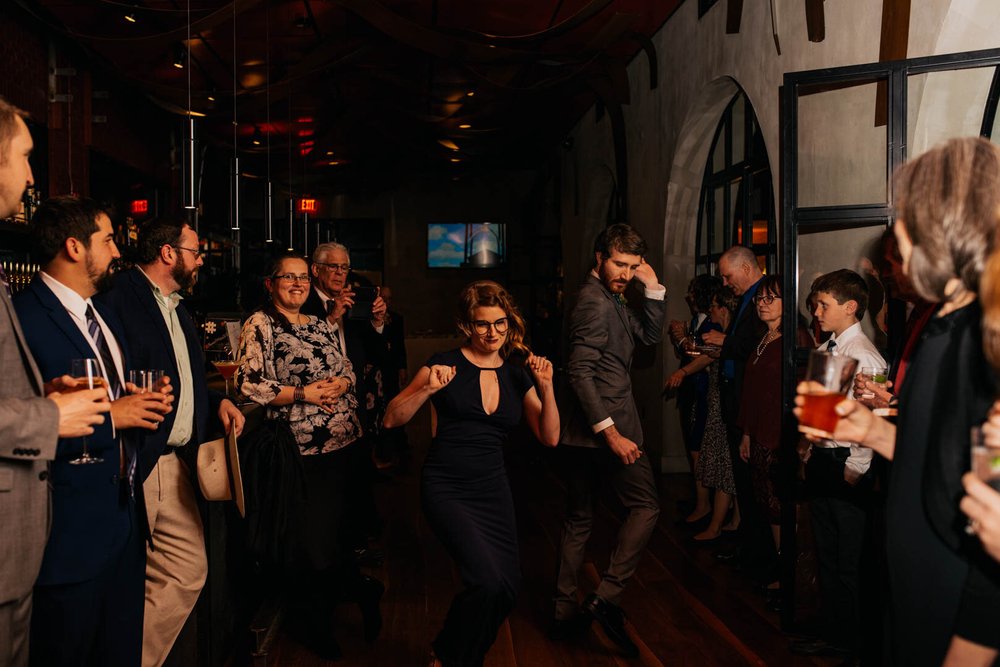 bridesmaid and groomsman dance their way into the reception space