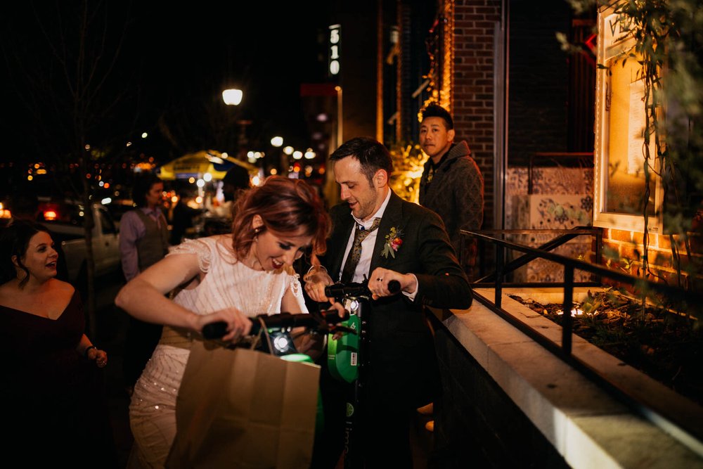 bride and groom get on their lime scooters after their wedding