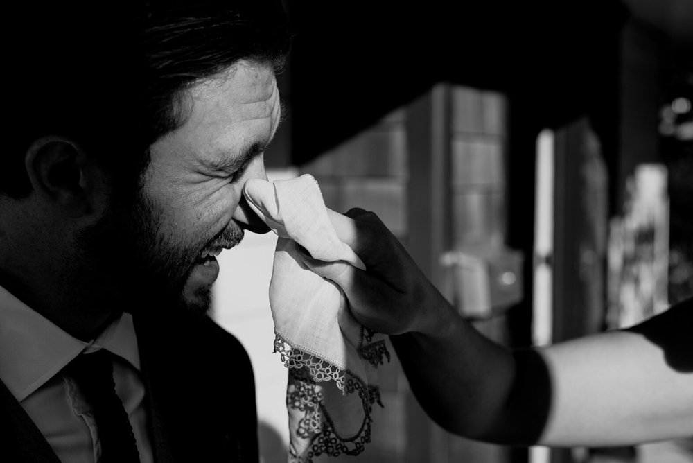 bride wiping away tears in grooms eye