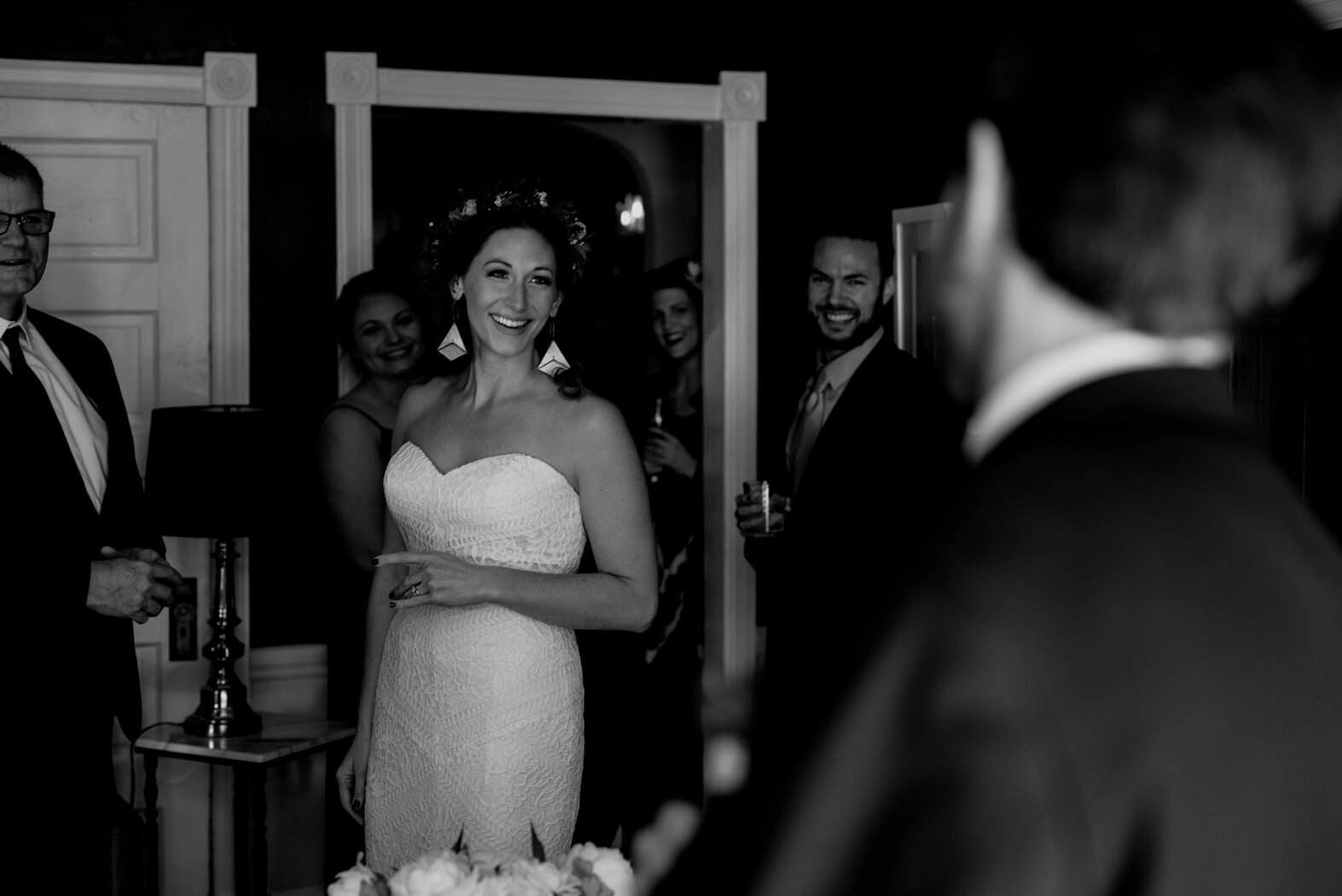 bride laughing with groom while standing with her family