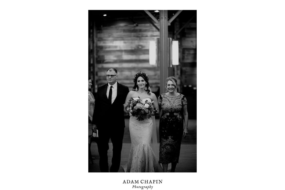 bride walking with her mother and father at the beginning of the wedding ceremony