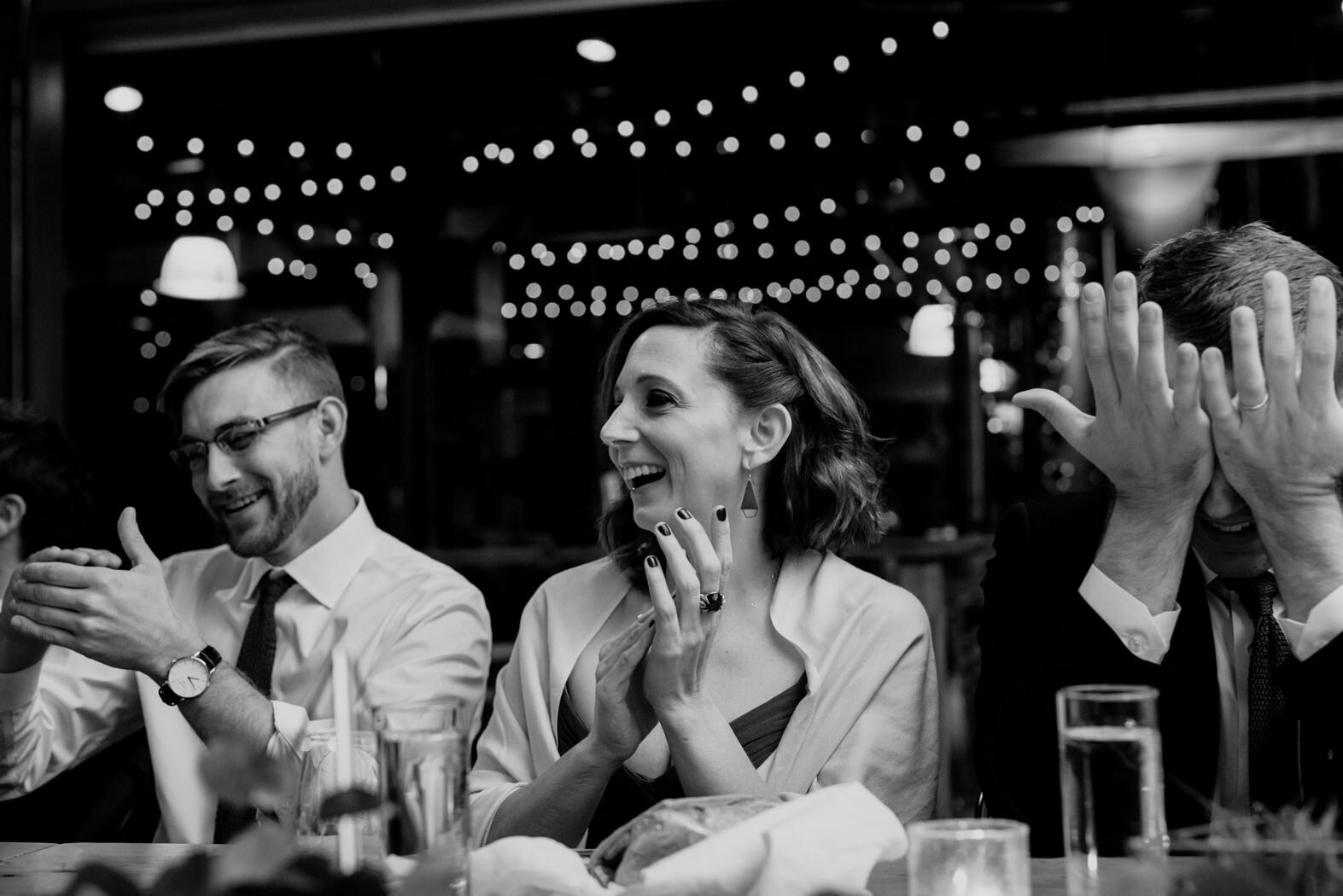 guests clapping and covering their eyes during toasts