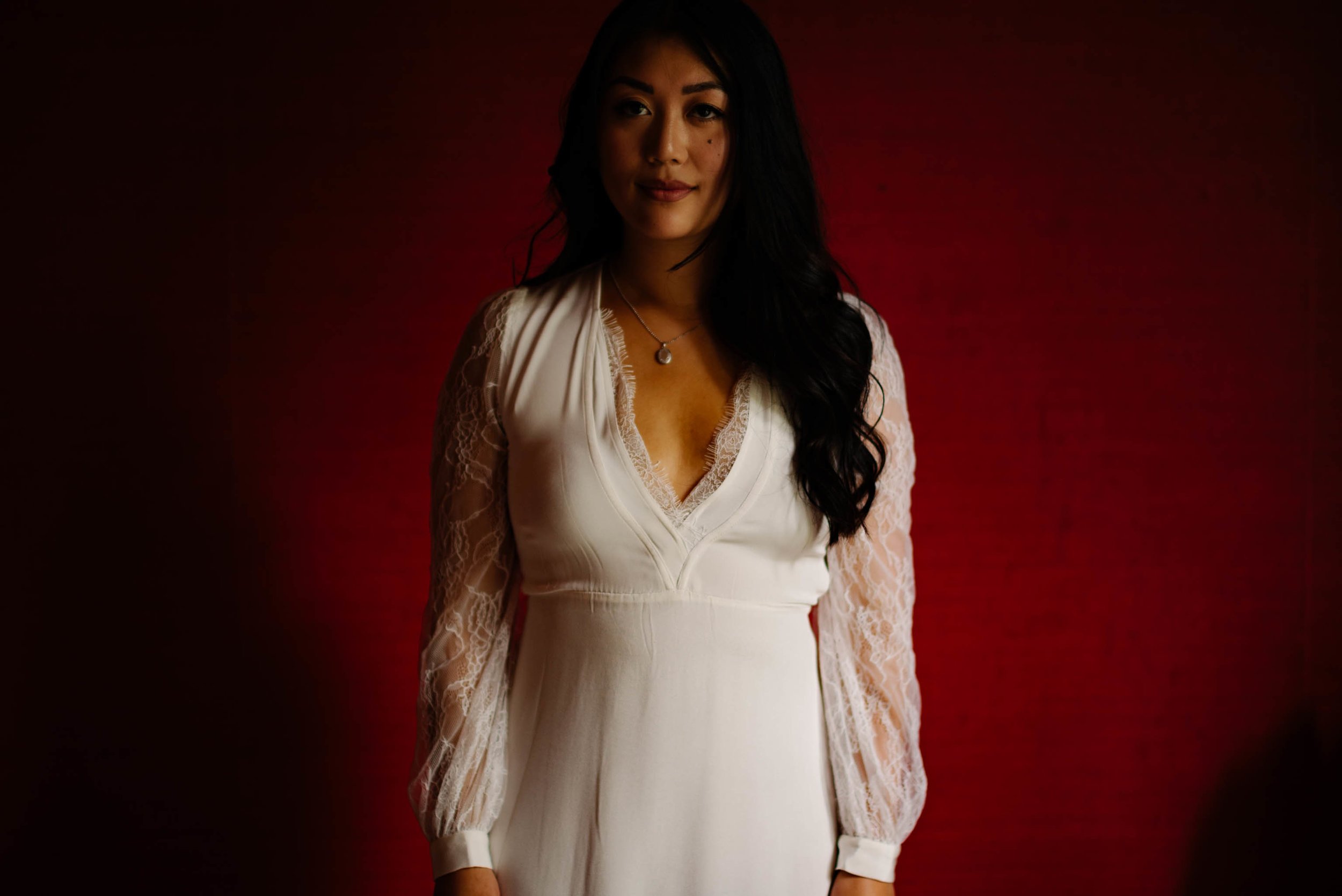 Bride standing in front of rusty red wall