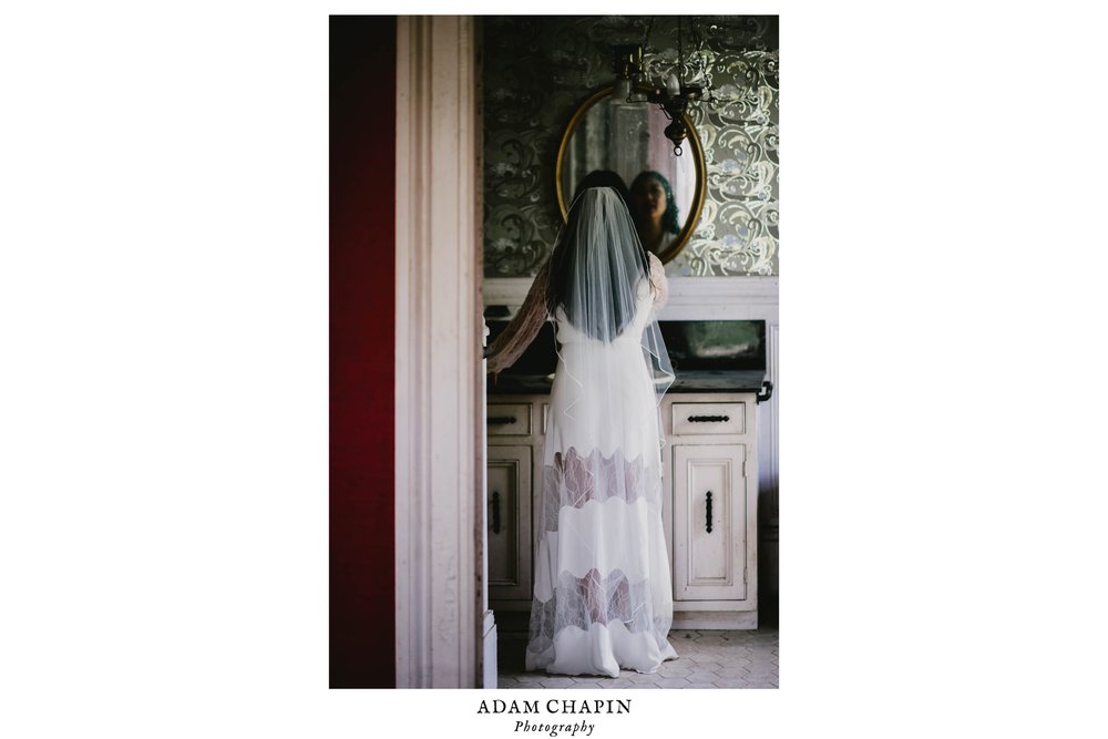bride fixing her veil in the antique bathroom mirror of the Montfort House in Raleigh, NC