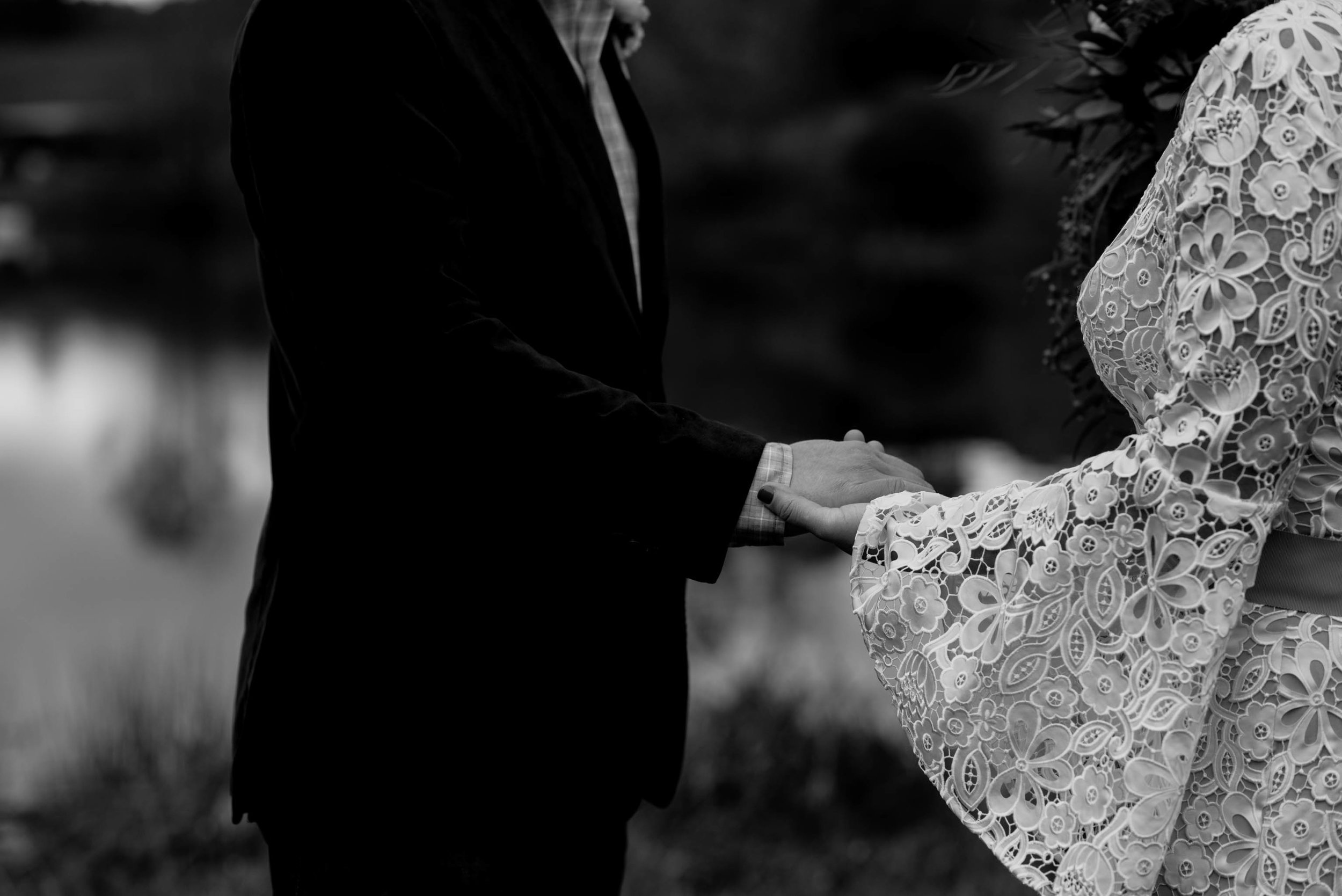 black and white photograph of bride and groom holding hands